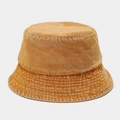 Macro shot of amber washed denim bucket hat showing vintage texture and stitching - Yellow