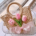 Detail view of woven straw handbag featuring delicate pink tulips and pearl decorations - A2 Circular Handbag
