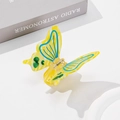 Pince à cheveux papillon jaune avec taches vertes et motif bleu sur un livre - Jaune