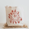 Off-white canvas tote bag featuring spooky vibes print with spider web and melting face - Spooky Vibes Rust Red Melting Smiley