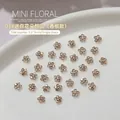 Mini bloemen nail art bedeltjes in champagne goud met sprankelende metalen basis - Champagne (1 stuk)