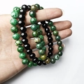 Detailed view of three 8mm tiger eye and turquoise bead bracelets held in a palm - Set of 3 / Green and Black