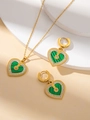 Detailset Goldschmuck mit Herzform, grüner Textur und Kristallen auf weißem Podest - Grünes Strass Herz Halskette Und Ohrringe