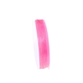 Macro view of pink translucent crystal elastic string on a white plastic spool for DIY jewelry - Pink