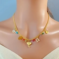 Collana bohémien dorata con ciondoli colorati a forma di elefante indossata da una modella - Oro