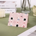 Tarjeta de felicitación rosa con motivos de conejos y tazas de café en un escritorio - Conejo café