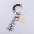 Close-up of silicone beaded wristlet keychain with MAMA wood charm and leopard tassel - Cow