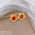 Detailed view of gold flower stud earrings with red gemstones on a display tray - Rose Flower Stud Earrings (P534)