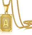 Macro shot of gold A-Z initial pendant necklace with box chain on reflective surface - Letter A
