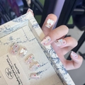 Close-up of French nude nails with colorful polka dots, white bows, and floral charms - By1650 Camp Song And Butterfly Dance / Glue Type