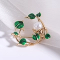 Dettaglio di una spilla floreale dorata con foglie in smalto verde e perla centrale - Bianco (MM-BR-3170)