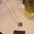 Golden bead chain necklace featuring a purple heart gemstone pendant with starburst motif - Amethyst