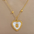 Primer plano detallado de un colgante de corazón dorado con nácar y letra V metálica - Dorado (P201 Dorado)