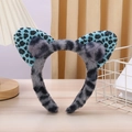 Detailed view of gray plush cat ear headband with blue leopard print and fluffy pom-poms - Blue Leopard