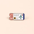Pink and blue enamel travel pin featuring Adventure Awaits text and airplane motif - Pink