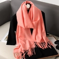 Pink-orange faux cashmere scarf with tassels draped on a mannequin stand - Sunstone