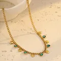 Vista macro del collar de acero dorado con corazones de strass verdes y medidas exactas - Corazón / Verde