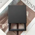 Caja joyero deslizante negro mate minimalista con cinta de seda sobre fondo de revista antigua - Negro/Interior 9x9x2cm/Sin Impresión