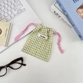 Detailed view of checkered drawstring pouch with yellow and blue plaid on desk - Yellow Grid