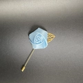 Close-up of light blue fabric rose brooch with golden hollow leaf and long stick pin - Light Blue