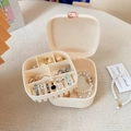 Detail of cream jewelry box showing two-tier storage for rings and pearl necklace - White
