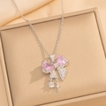 Close-up of silver bow necklace with pink heart crystals on a beige jewelry box - Silver Pink Necklace