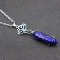 Macro detail of hexagonal blue crystal pendant with wire wrap and lotus metal charm - Lotus + Lapis Lazuli