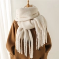 Dettaglio di una sciarpa in mohair bianco crema con spesse frange su un cappotto cammello - Bianco Sporco