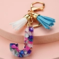 Detail of letter J keychain with colorful stone inlay and blue and white tassels - Letter J