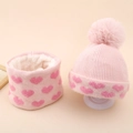 Close-up of pink knit hat and scarf set with heart patterns and warm fleece lining - Pink