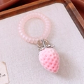 Close-up of pink spiral hair tie with detailed flocked strawberry pendant on fabric - Flocked Strawberry Pendant Style / Pink (Silver Alloy Buckle)