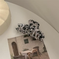 Detail of large acetate hair claw clip with black and white cow print and glossy finish - Black & White