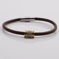 Dettaglio del bracciale in pelle marrone con perla dorata e zirconi e chiusura magnetica - Marrone / Oro