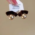 Dettaglio di orecchini vintage in velluto con grandi perle dorate e argento - Stile Velluto Marrone
