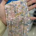 Perle naturali di morganite in tonalità pastello rosa, blu e giallo tenute in mano - Prezzo per Filo Singolo / Grado A 6mm (Circa 60 Perline/Filo)
