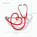 Dettaglio della spilla a stetoscopio con cuore rosso, misure 3,5x3,7cm e un peso di 7g - Spilla Stetoscopio a Cuore Rosso / Rosso/Oro