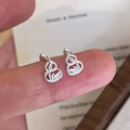 Elegant silver-plated hollow gourd stud earrings shown on fingertip for size reference - Hollow Gourd Shape Style (A317)