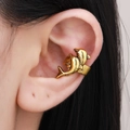 Close-up of a golden double dolphin ear cuff on a model's ear cartilage - Antique Gold (X146)