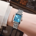 Elegant silver square watch with blue dial on woman wrist in a cozy cafe setting - Silver Blue Dial