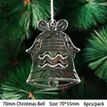 Close-up of clear acrylic Christmas bell ornaments with ribbon on green pine branches - 70mm Christmas Bell