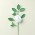 Detailed close-up of a hand-knitted white rose branch with green leaves and flower buds - White