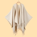 Detail of beige knitted shawl on a wooden hanger with decorative fringe finish - Beige