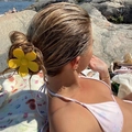 Large yellow flower claw clip hair accessory worn by model at a sunny summer beach side - Yellow