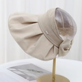 Détail de visière beige montrant le logo métallique latéral et le nœud arrière - Kaki