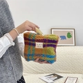 Detail of colorful plaid plush bag being filled with cosmetics in a cozy home setting - Multi Color Grid