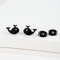 Detailed view of minimalist black whale-shaped stud earrings on a white stone base - 275 Black (Whale)