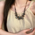 Collar bohemio de cuentas de cerámica con esmalte étnico usado por una modelo - Collar de Cuentas Gris Azulado