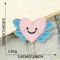 Pink heart embroidery patch with blue wings and smiley face for DIY clothing decor - Pink Winged Smile (B1L-C-1-5)