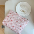 Détail d'une trousse à maquillage matelassée rose avec motifs floraux et étiquette simple - Rose à Pois Fleuri