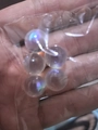 Iridescent glass beads in 12mm size for DIY crafts shown in a small clear plastic bag - 12mm Holeless / Iridescent Clear
